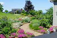 Replacements for the overgrown plant materials include a variety of mid-spring through summer-blooming perennials. Adjacent to the front walk these plants provide a distinctly English cottage garden effect.