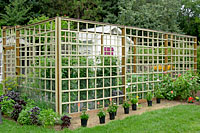 This wood frame garden enclosure is about fifteen feet wide, thirty feet long and eight feet high.
